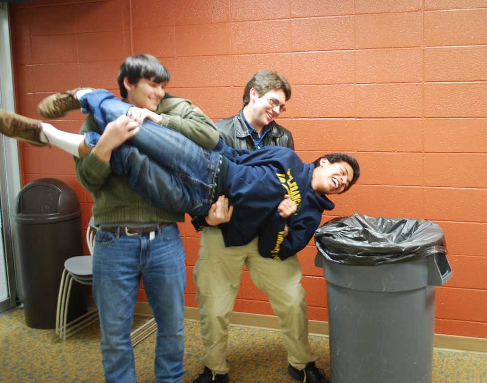Juniors Austin Shuemaker and Iain Morrison lift freshman Abel Klopfenstein into a trash can as a joke.