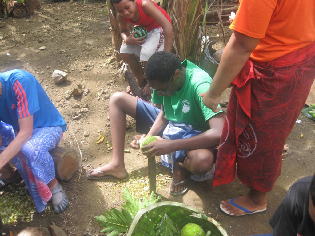 Skinning a local bread fruit for an afternoon meal is a common pasttime for Samoans.