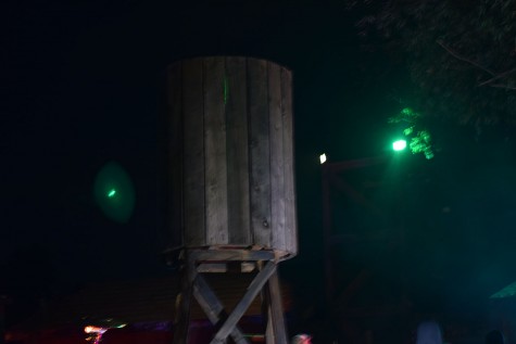 The green lights reflect off a wooden silo to give off an eerie feeling. 