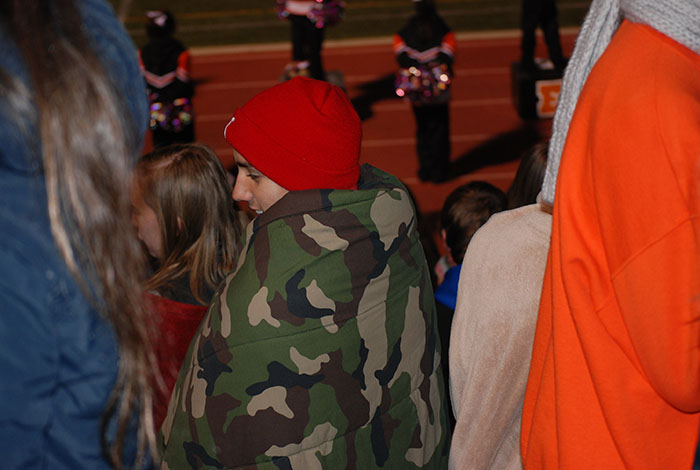 Students stand as a part of the Rowdy Rangers, supporting their football team.
