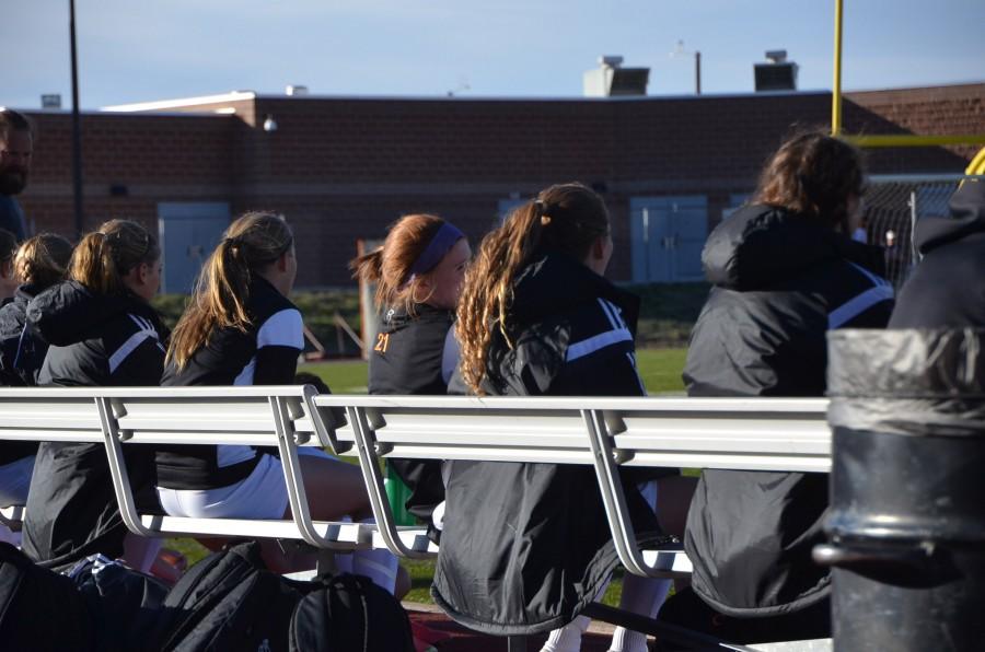 Girls soccer players cover up in the windy conditions