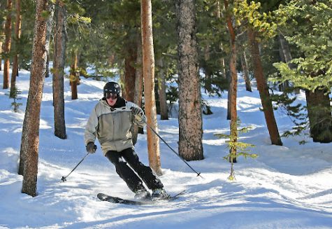 A skier that is skiing off the slopes in the forest. This picture was taken at Keystone.